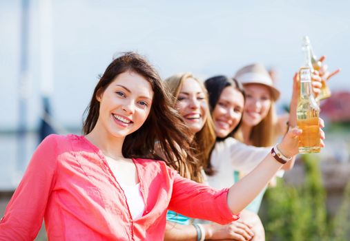 summer holidays and vacation - girls with drinks on the beach