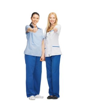 healthcare and medical concept - two doctors showing thumbs up