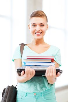 education concept - smiling student with folders and school bag in college