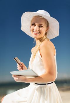 internet and lifestyle concept - beautiful woman in hat doing online shopping outdoors