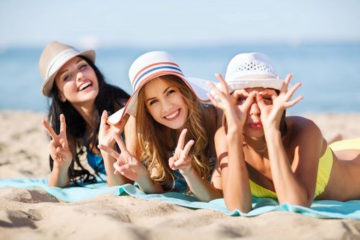 summer holidays and vacation - girls sunbathing on the beach