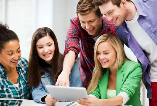 education and internet - smiling students looking at tablet pc in lecture at school