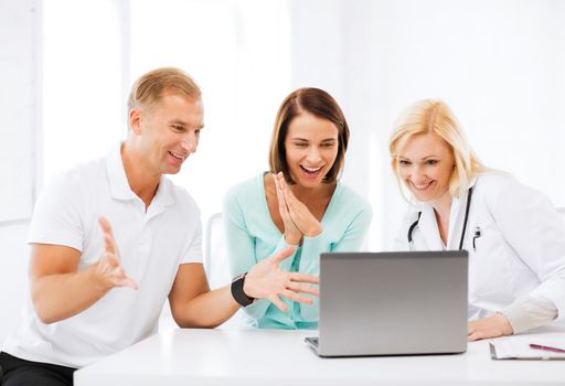 healthcare, medical and technology - doctor with patients looking at laptop