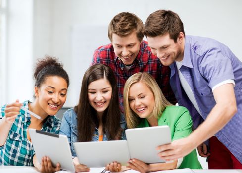 education and internet - smiling students looking at tablet pc in lecture at school