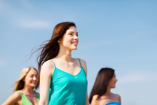 summer holidays and vacation - girl with friends walking on the beach