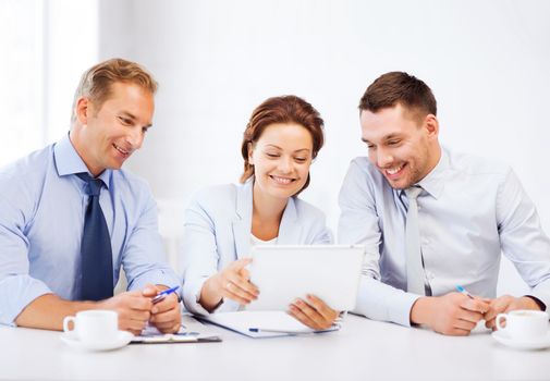 business and technology concept - business team looking at tablet pc in office