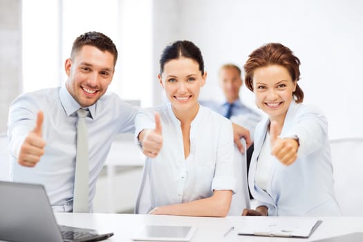 business concept - business team showing thumbs up in office