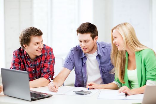 education concept - smiling students chatting in lecture at school