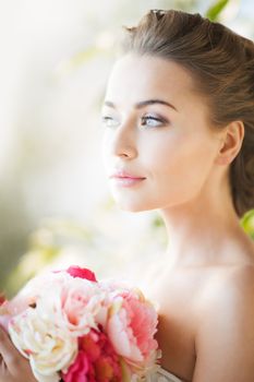 wedding and beauty concept - young woman with bouquet of flowers