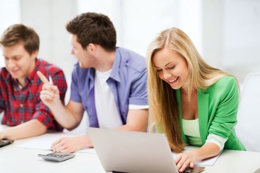 education and internet - smiling students writing test or exam in lecture at school