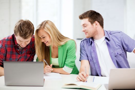 education concept - students writing something in notebooks at school