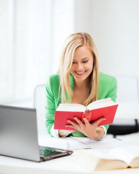 education concept - smiling student girl reading book in college