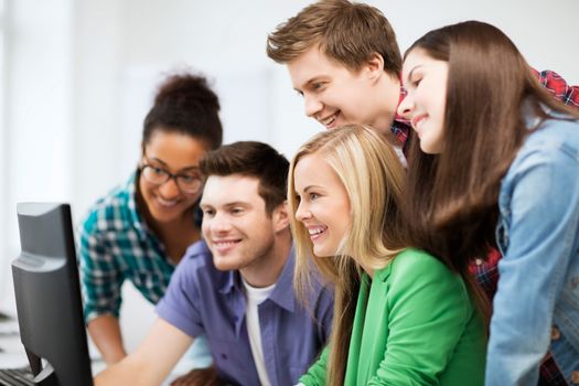 education concept - students looking at computer monitor at school