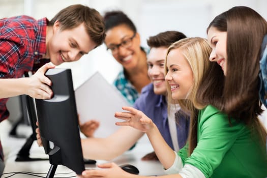 education concept - students looking at computer monitor at school