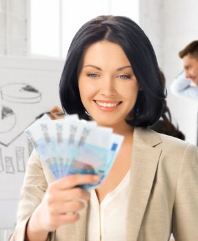 business concept - happy businesswoman with cash money in office