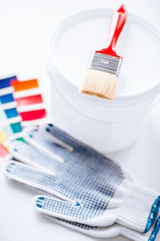 interior design and home renovation concept - paintbrush, paint pot, gloves and pantone samples