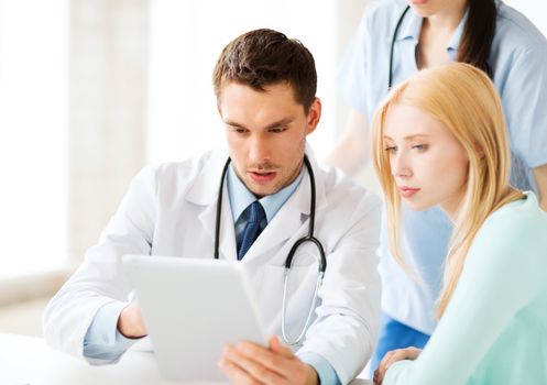 healthcare, medical and technology - doctor showing something patient on tablet pc in hospital