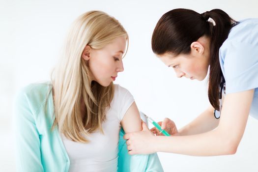 healthcare and medical concept - doctor doing vaccine to patient