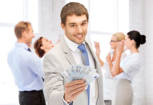 business concept - happy businessman with cash money in office