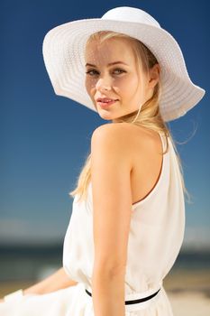 fashion and lifestyle concept - beautiful woman in hat enjoying summer outdoors