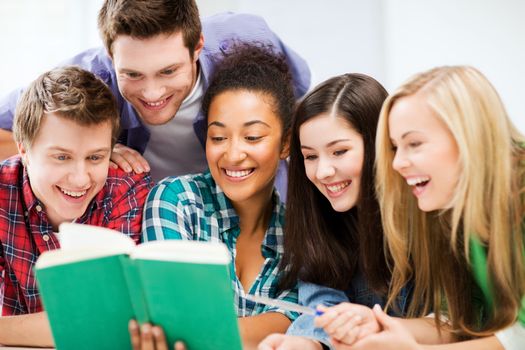 education concept - group of students reading book at school