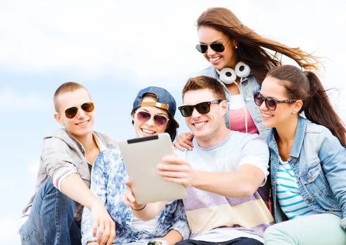 summer holidays, teenage and technology concept - group of teenagers taking picture with tablet pc