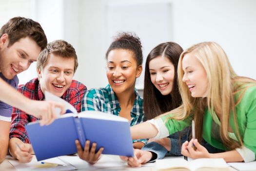 education concept - group of students reading book at school