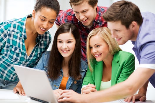 education and internet - smiling students looking at tablet pc in lecture at school