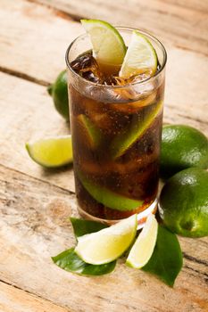 drink concept - cocktail with cola ice cubes and lime