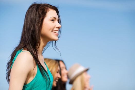 summer holidays and vacation - girl with friends walking on the beach