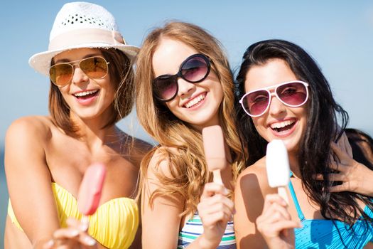 summer holidays and vacation - girls in bikinis eating ice cream on the beach