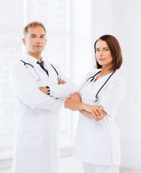 healthcare and medical concept - two doctors with stethoscopes