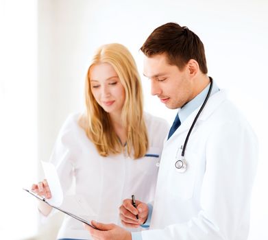 healthcare and medical concept - two doctors writing prescription