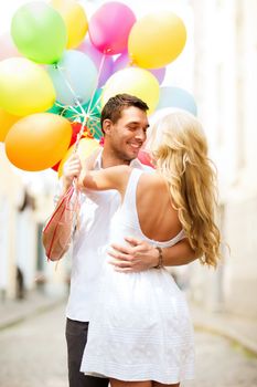 summer holidays, celebration and dating concept - couple with colorful balloons in the city