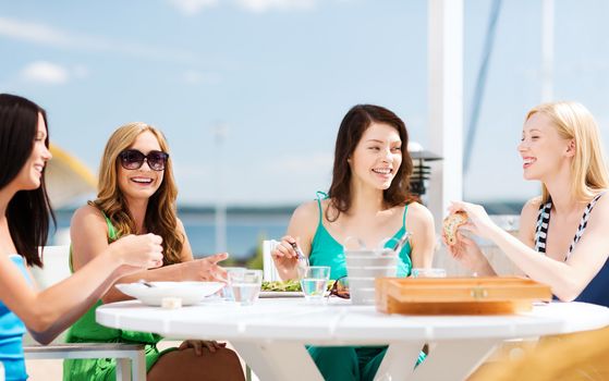 summer holidays and vacation - girls in cafe on the beach