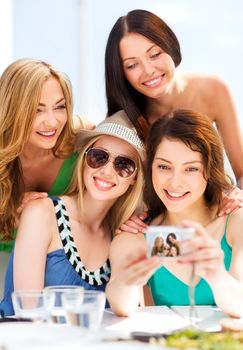 summer holidays and vacation - girls taking photo in cafe on the beach