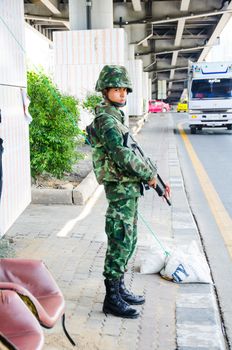 BANGKOK - MAY 25: Soldier search weapons or person on the road after military coup on May 25, 2014 in Bangkok, Thailand.