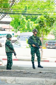 BANGKOK - MAY 24: Soldier search weapons or person on the road after military coup on May 24, 2014 in Bangkok, Thailand.