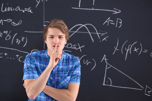 Student at blackboard background saved mathematical formulas