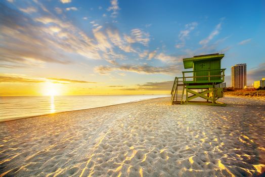 Miami South Beach sunrise with lifeguard tower and coastline with colorful cloud and blue sky. 