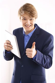 Portrait of a young elegant man in blue suit holding a digital tablet