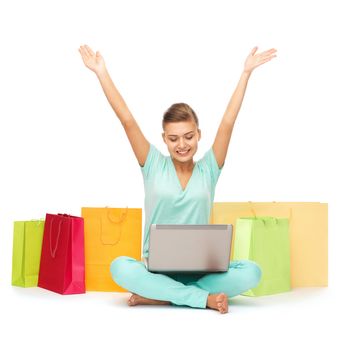 shopping, internet and home concept - woman with laptop and shopping bags