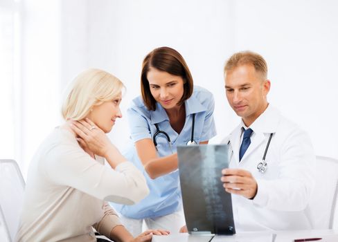 healthcare, medical and radiology concept - doctors with patient looking at x-ray