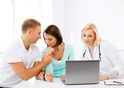 healthcare, medical and technology concept - doctor with patients looking at laptop