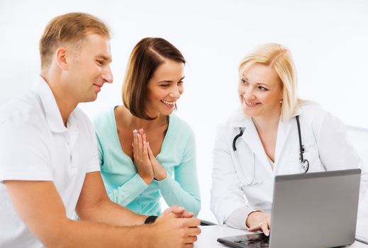 healthcare, medical and technology - doctor with patients looking at laptop