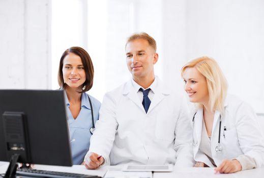 healthcare, medical and technology - group of doctors looking at computer on meeting