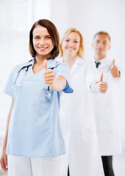 healthcare and medical concept - team of doctors showing thumbs up