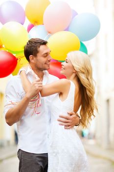 summer holidays, celebration and dating concept - couple with colorful balloons in the city