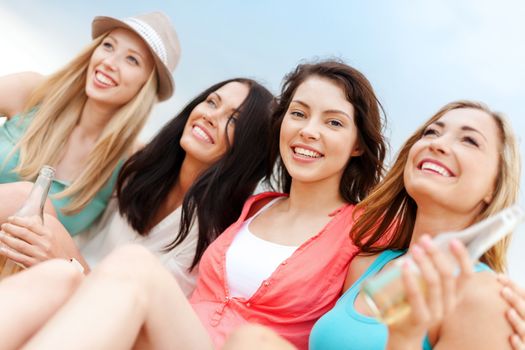 summer holidays and vacation concept - girls with drinks on the beach