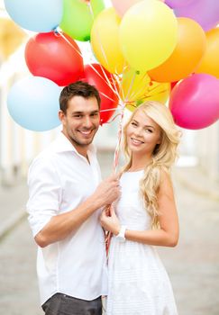 summer holidays, celebration and dating concept - couple with colorful balloons in the city